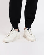 Brethe Free-Form Jogger in Black showing ribbed cuff leg opening with sneakers.