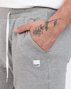 Brethe Free-Form Jogger in Heather Grey close-up of side pocket with Brethe logo patch.