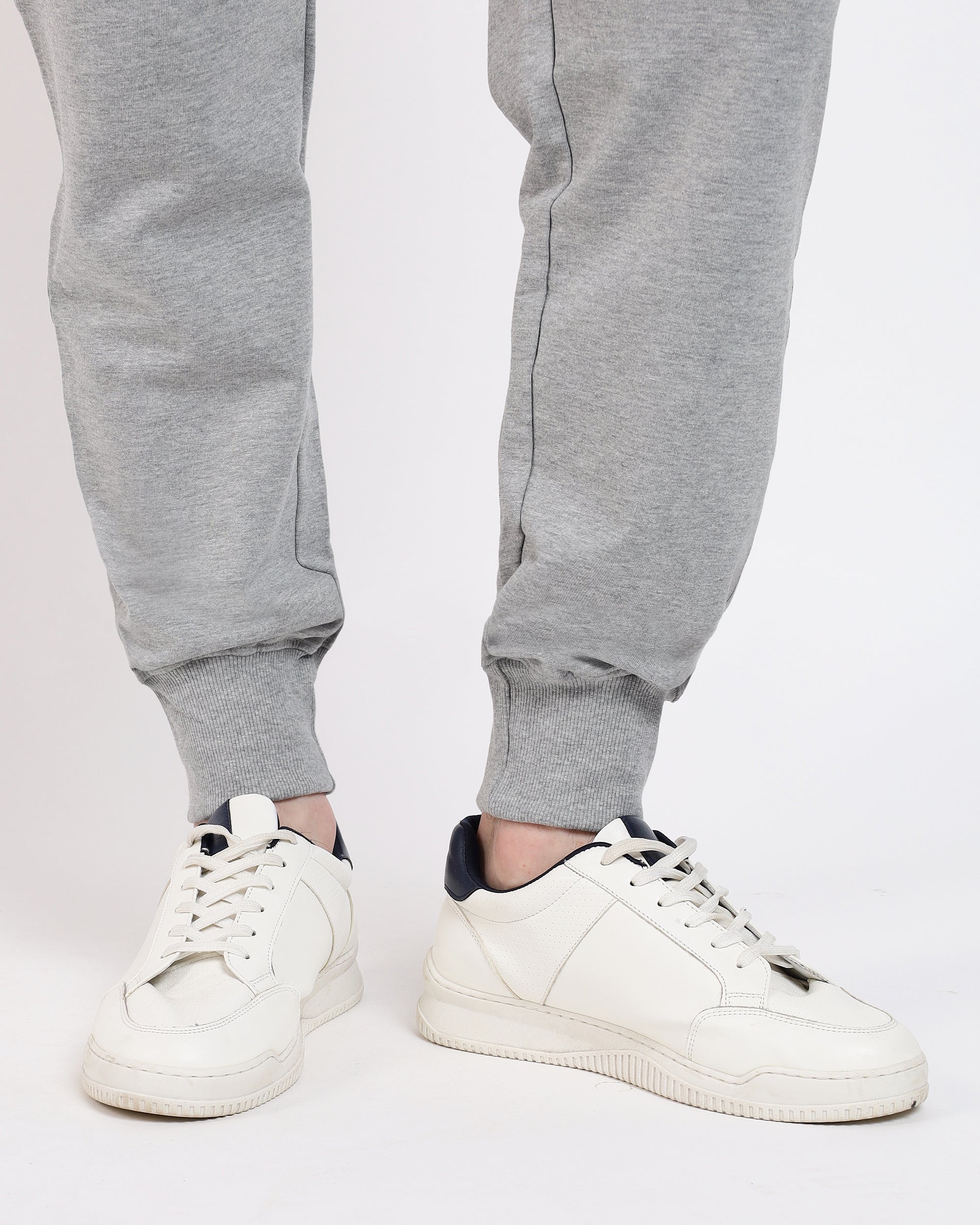 Brethe Free Form Jogger in Heather grey showing ribbed cuff leg opening with sneakers.