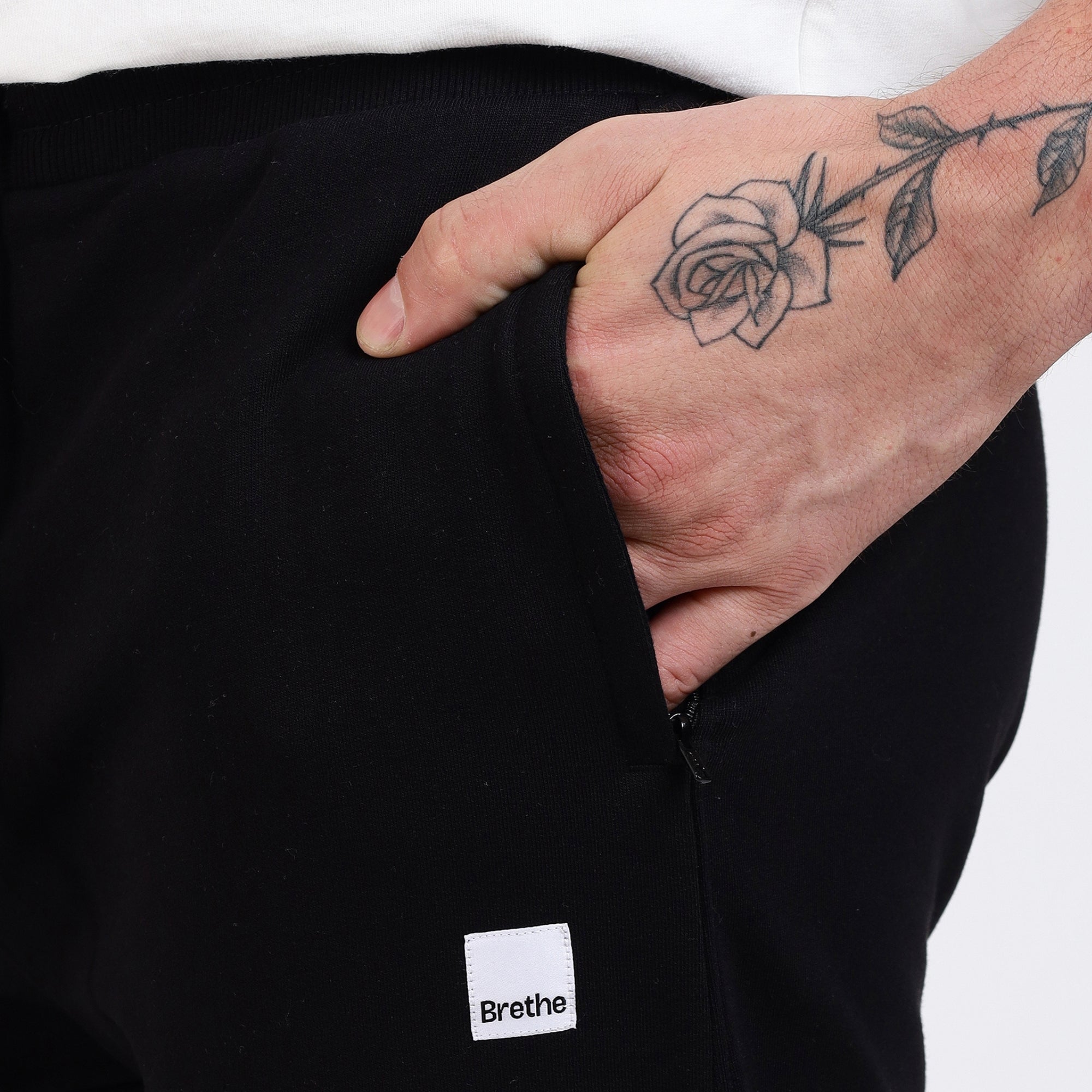 Brethe Soft structured pant in Black close-up showing side pocket with Brethe logo patch.