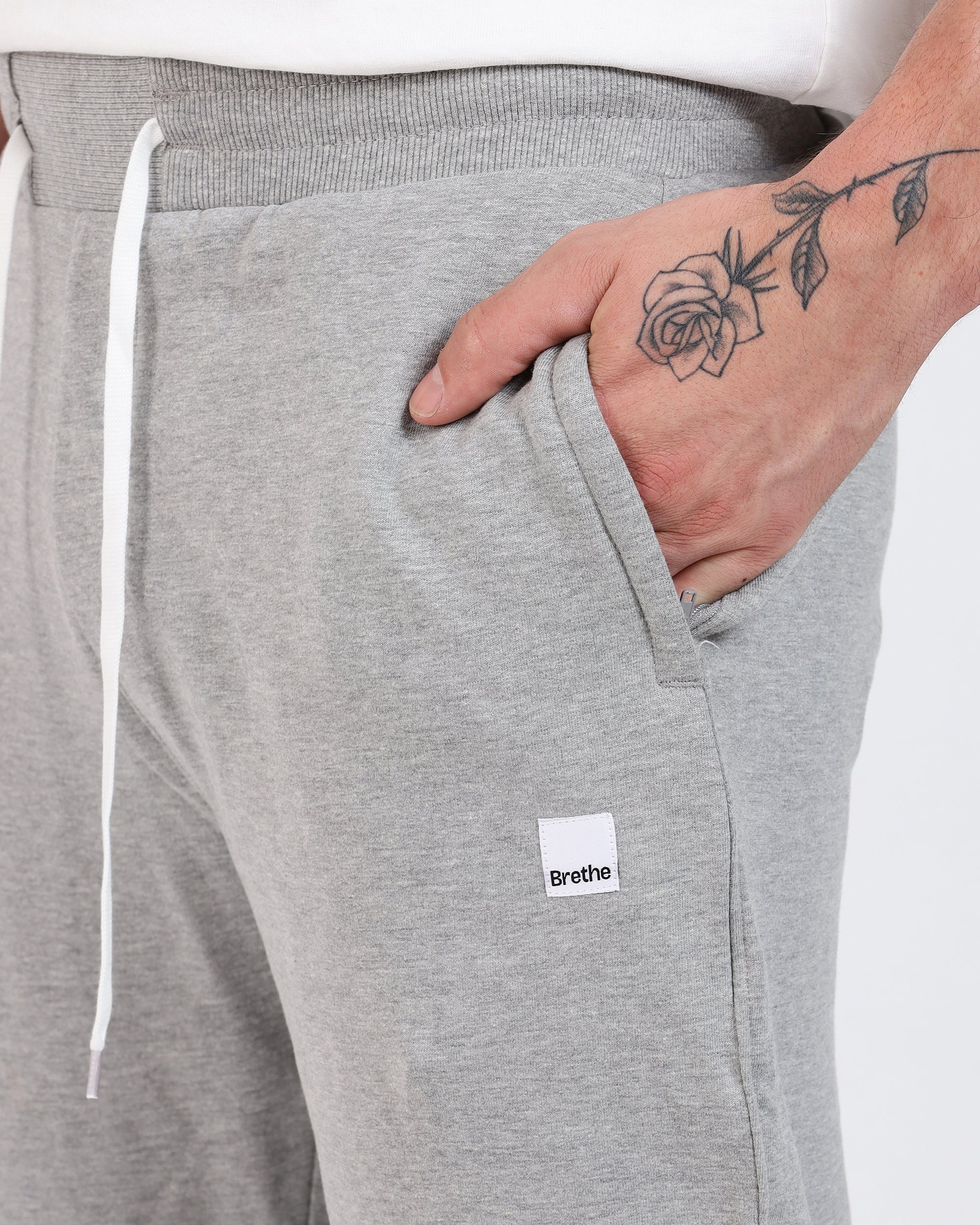 Brethe Soft-Structured Pant worn by a model in Heather Grey close-up of side pocket with Brethe logo label.