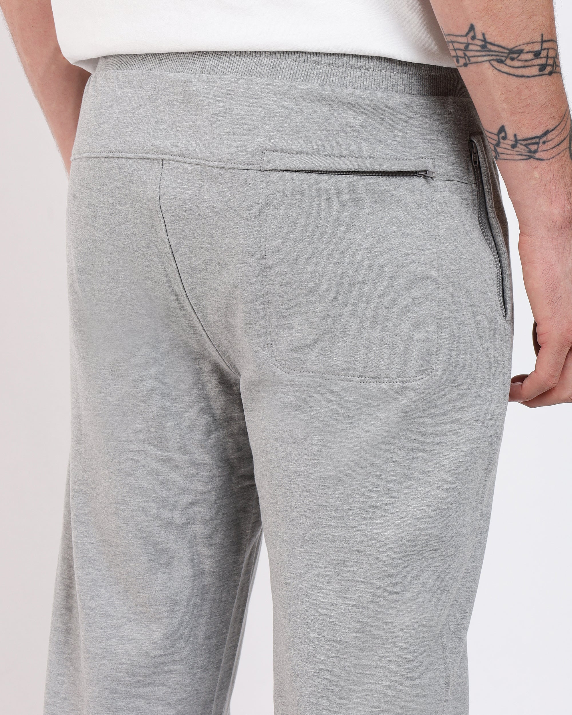 Heather grey Soft-Structured Pant by Brethe, worn by a model back view showing yoke, back pocket, and ribbed waistband.